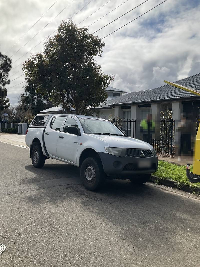 White Mitsubishi Triton parked on a suburban street, Brighton