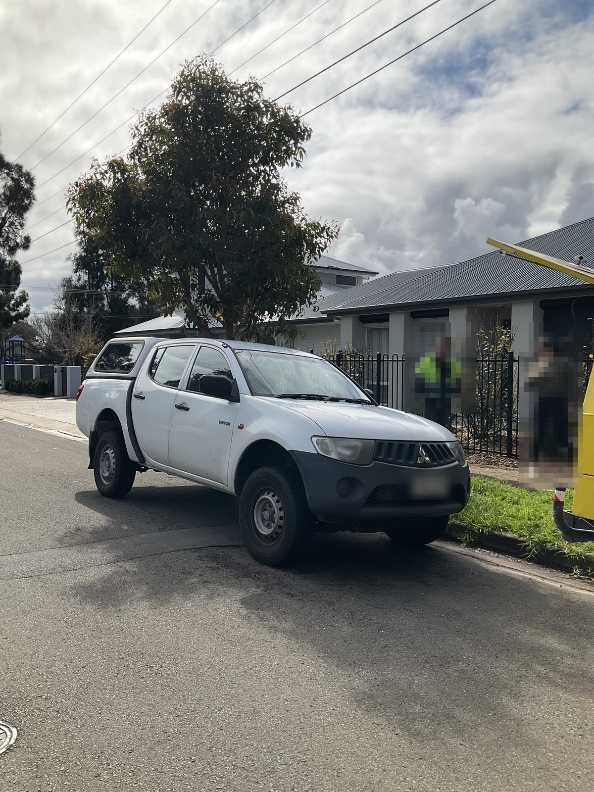 White Mitsubishi Triton parked on a suburban street, Brighton